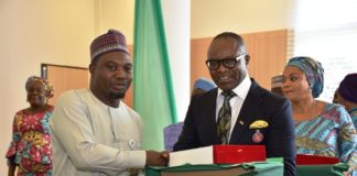 Dr. Emmanuel Ibe Kachikwu, Honourable Minister of Petroleum Resources giving an award to outstanding performing officer
