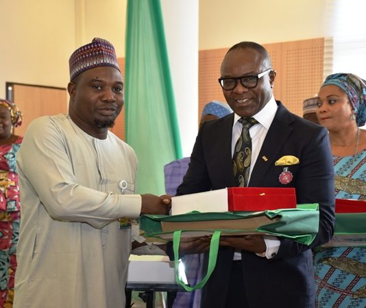 Dr. Emmanuel Ibe Kachikwu, Honourable Minister of Petroleum Resources giving an award to outstanding performing officer