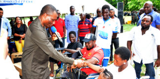 Minister of Niger Delta Affairs, Pastor Usani Uguru Usani (left), presenting wheel chairs to some of the physically challenged persons.