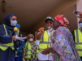 Right; The Honourable Minister of Humanitarian Affairs, Disaster Management and Social Development, Hajiya Sadiya Umar Farouq presenting cash to one of the beneficiaries of the Conditional Cash Transfer Programme.