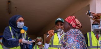 Right; The Honourable Minister of Humanitarian Affairs, Disaster Management and Social Development, Hajiya Sadiya Umar Farouq presenting cash to one of the beneficiaries of the Conditional Cash Transfer Programme.