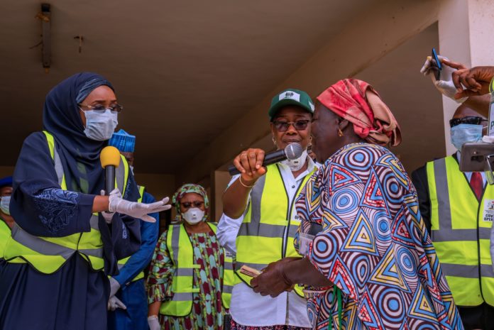 DSC00747 Right; The Honourable Minister of Humanitarian Affairs, Disaster Management and Social Development, Hajiya Sadiya Umar Farouq presenting cash to one of the beneficiaries of the Conditional Cash Transfer Programme.