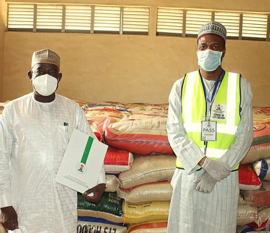 Left; The Representative of the Honourable Minister of Humanitarian Affairs, Disaster Management and Social Development Hajia Sadiya Umar Farouq, (Deputy Director, Disaster Management of the Ministry, Dr. Abubakar Suleiman), handing over food items as part of the COVID-19 pandemic palliatives to the Representative of the Katsina State Governor, His Excellency, Alhaji Aminu Bello Masari (The Special Adviser and Focal Person on Humanitarian Affairs, Alhaji Abubakar Nasir)