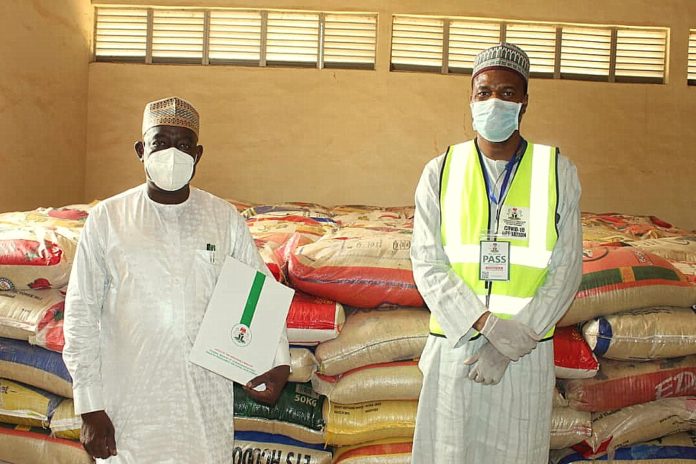 KPH1 4-18-2020 8-15-06 PM 1080x720.22 PM Left; The Representative of the Honourable Minister of Humanitarian Affairs, Disaster Management and Social Development Hajia Sadiya Umar Farouq, (Deputy Director, Disaster Management of the Ministry, Dr. Abubakar Suleiman), handing over food items as part of the COVID-19 pandemic palliatives to the Representative of the Katsina State Governor, His Excellency, Alhaji Aminu Bello Masari (The Special Adviser and Focal Person on Humanitarian Affairs, Alhaji Abubakar Nasir)