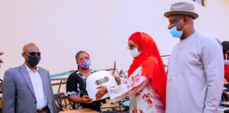 (2nd right) Honourable Minister of Humanitarian Affairs Disaster Management and Social Development, Sadiya Umar Farouq, giving relief materials to one of the victims of the Ogbeogonogo market fire during the flag off for the distribution of the relief items for reconstruction and development of new shops at the market in Delta State