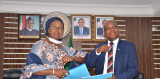 In-coming Permanent Secretary, Dr. Oluwatoyin Akinlade (l), receiving handing-over notes from Out-going Permanent Secretary, Mr. Edet Akpan
