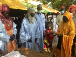 (2nd Right), Representative of the Minister of Humanitarian Affairs, Deputy Director Humanitarian Affairs, Dr. Sulieman Abubakar, (3rd Right) Representative of the Emir of Katagum, Alhaji Aliyu Hussaini, presenting grant to a beneficiary during the flag off of the Federal government Grant for Rural Women Project in Katagum, Bauchi State.