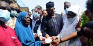 Representative of the Honourable Minister of Humanitarian Affairs, Disaster Management and Social Development, Director, Human Resource Management, Mr. Abdurahman Babatunde Jaji (3rd r); Village head of Karubiyi, Chief Dauda Dogo (r); Country Director of World Food Programme, Paul Howe (4th r); beneficiary, Mrs. Hadiza Isa and others, during the distribution of cash and food assistance to vulnerable people in Karamajiji, Abuja, on Friday 20th November 2020.