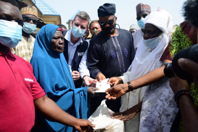 FHMADMSD WFP Representative of the Honourable Minister of Humanitarian Affairs, Disaster Management and Social Development, Director, Human Resource Management, Mr. Abdurahman Babatunde Jaji (3rd r); Village head of Karubiyi, Chief Dauda Dogo (r); Country Director of World Food Programme, Paul Howe (4th r); beneficiary, Mrs. Hadiza Isa and others, during the distribution of cash and food assistance to vulnerable people in Karamajiji, Abuja, on Friday 20th November 2020.