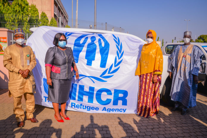 FMHADMSD, UNHCR (2nd R) The Honourable Minister of Humanitarian Affairs, Disaster Management and Social Development, Sadiya Umar Farouq, (2nd L) Country Representative United Nations High Commissioner for Refugees in Nigeria, Mme Chansa Kapaya, (1st R) Director Humanitarian Affairs of the Ministry, Ali Grema, (1st L) Representative of Hon. Federal Commissioner for Refugees, Migrants and Internally Displaced Persons, Ejibunu Tai Hassan, during the handing over of vehicles to the Federal government by UNHCR, in Abuja. Photo by Khalid Ahmed.