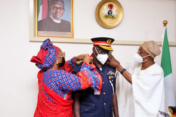 Wife of the CG, NSCDC, Hajiya Aisha Ahmed Audi (Left) assisting the Minister of Interior, Ogbeni Rauf Aregbesola (Right) to decorate the new CG, Ahmed Abubakar Audi(Middle) with his new rank Wife of the CG, NSCDC, Hajiya Aisha Ahmed Audi (Left) assisting the Minister of Interior, Ogbeni Rauf Aregbesola (Right) to decorate the new CG, Ahmed Abubakar Audi(Middle) with his new rank