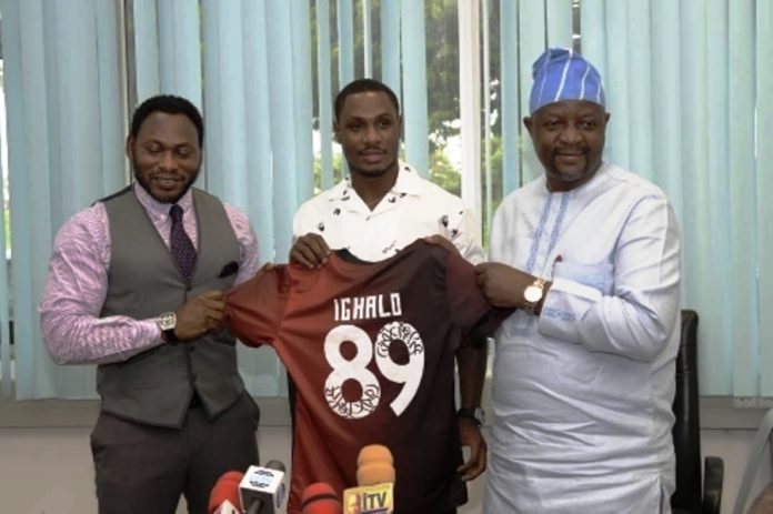 R-L: Hon. Minister of Youth and Sports Devlpt. Mr. Sunday Dare; holding Manchester United Jersey bearing IGHALO No. 89: with Odion Ighalo (Middle); and Daniel Amokachie, S.A. Sports to Mr. President.