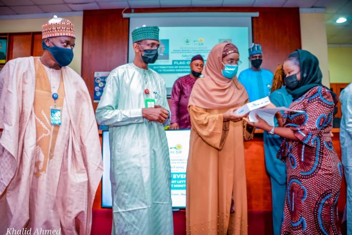IMG-20210610-WA0000 (3rd Left) The Honourable Minster of Humanitarian Affairs, Disaster Management and Social Development, Sadiya Umar Farouq, (2nd Left) the Permanent Secretary of the Ministry, Bashir Nura Alkali, (1st Left) National Coordinator for NSIP, Engr. Umar B. Bindir, (1st Right) an Independent Monitor, Aisha H. Ihiabe, during the Flag - Off, of the distribution of engagement letters and monitoring devices to Independent Monitors, on 10th June, 2021, in Abuja. Photo: Khalid Ahmed.