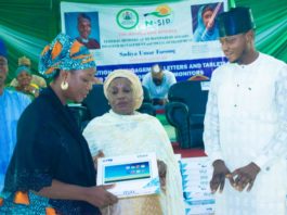 (middle) Representative of the Honourable Minister of Humanitarian Affairs, Disaster Management and Social Development, Sadiya Umar Farouq, the Deputy Director, Planning, Research and Statistics of the Ministry, Safiya Sani, (Right) Kogi State Focal Person on NSIP, Abdulkareem Suleiman, presenting engagement letter and tablet to (left) trained Independent Monitor, Mummy Rekiya Mohammed, during the flag off ceremony of the distribution of engagement letters and tablets to trained Independent Monitors in Kogi State, Wednesday June 30th, 2021