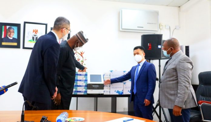 SGF, Boss Mustapha (2nd) inspecting Covid-19 test kits donated by Ustar, MD, CGCOC, Ye Shuijin (2nd R) showcasing Covid-19 test kits, PS (GSO), Dr. Nnamdi Maurice and a staff with CGCOC