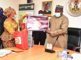 The National Coordinator/CEO SERVICOM, Mrs Nnenna Akajemeli presenting items from Servicom to the PS, Dr. Nasir Sani Gwarzo, mni, NPOM