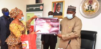The National Coordinator/CEO SERVICOM, Mrs Nnenna Akajemeli presenting items from Servicom to the PS, Dr. Nasir Sani Gwarzo, mni, NPOM