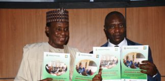 Minister of Defence, Maj Gen Bashir Salihi Magashi (L) and the Permanent Secretary, Musa Istifanus (R) with the SSD manual
