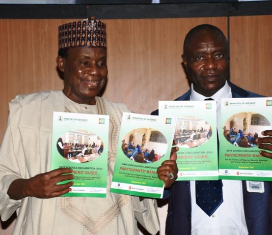 Minister of Defence, Maj Gen Bashir Salihi Magashi (L) and the Permanent Secretary, Musa Istifanus (R) with the SSD manual