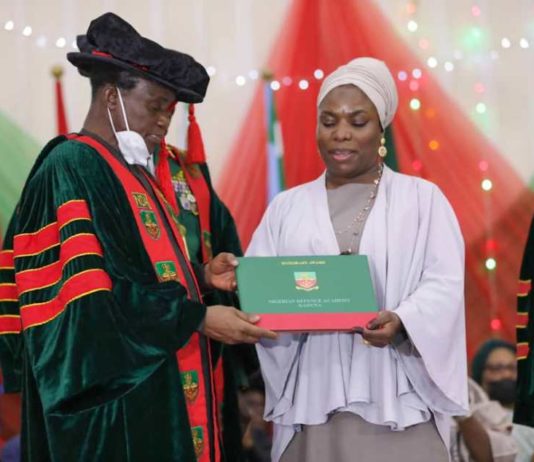 he Minister of Defence presenting the Honorary Degree to the immediate past Chief of Army Staff, Late Lt Gen Ibrahim Attahiru' s widow.