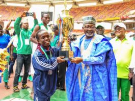Representative of the Hon. Minister of Youth and Sports Development, Mr Sunday Dare presenting trophy to Tram Bayelsa, winner of the maiden edition of 2022 Para Games in Abuja.