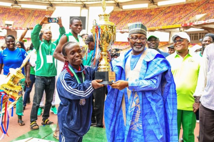 Team Bayelsa Representative of the Hon. Minister of Youth and Sports Development, Mr Sunday Dare presenting trophy to Tram Bayelsa, winner of the maiden edition of 2022 Para Games in Abuja.