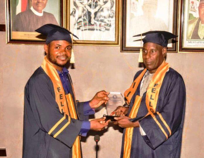 L-R, the Program Director, IIPM, Eburuche Banito, presenting Award to Permanent Secretary's representative, Mr. Ibrahim Bello, during Award ceremony in the Ministry.