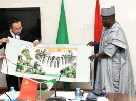 Permanent Secretary, Ministry of Defence, Dr Ibrahim Abubakar Kana, mni, receiving a souvenir from the leader of SASTIND delegation from China, Lin Yunteng, during the visit to Ship House, Abuja.