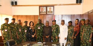 The Minister of Defence, Maj Gen Bashir Salihi Magashi (rtd)(M) and the management team of the Ministry with the Chief of Defence Space Administration, Air Vice Marshal Ayo Jolasinmi (6th L) and his team in a group picture in Ship House, Abuja