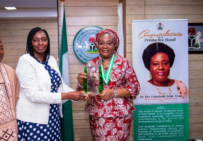 National Productivity order of Merit Award Head of the Civil Service of the Federation, Dr. Folasade Yemi-Esan, Receiving the plaque from the PS, Federal Ministry of Labour and Employement, Ms Kachallom Daju mni, during the National Productivity order of Merit Award (MPOM) Confered on the Head of the Civil service of the Federation, in Abuja.