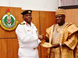 The Permanent Secretary, MOD, Dr. Ibrahim Abubakar Kana, mni receiving a plague from the Commandant of NDC, Rear Admiral O.M. Olotu.
