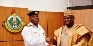 The Permanent Secretary, MOD, Dr. Ibrahim Abubakar Kana, mni receiving a plague from the Commandant of NDC, Rear Admiral O.M. Olotu.