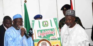 Honourable Minister of Defence, Mohammed Badaru Abubakar CON, mni [R] receiving a congratulatory card from Jigawa State delegation led by Governor Malam Umar Namadi, FCA during the courtesy visit.