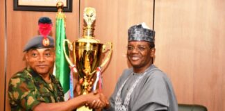 Minister of Defence for State Dr Muhammad Bello Matawalle receiving the trophies won by the Navy cadets in China during the sailing competition from Maj Gen JO Ochai, the Commandant of Nigeria Defence Academy (NDA) in Ship House, Abuja