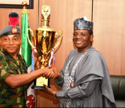 Minister of Defence for State Dr Muhammad Bello Matawalle receiving the trophies won by the Navy cadets in China during the sailing competition from Maj Gen JO Ochai, the Commandant of Nigeria Defence Academy (NDA) in Ship House, Abuja