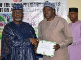 Permanent Secretary, FMAFS, Dr Ernest Umakhihe, presenting Certificate of Attendance to Deputy Director, Engr. Julius Ayodele during the workshop in Abuja