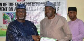Permanent Secretary, FMAFS, Dr Ernest Umakhihe, presenting Certificate of Attendance to Deputy Director, Engr. Julius Ayodele during the workshop in Abuja
