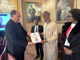 Senior Director, Trade, Oceans and Natural Resources, Paul Kautoke presenting a souvenir to the Minister of Solid Minerals Development, Dr. Oladele Alake. The Permanent Secretary, Dr.Mary Ogbe watches with keen interest.