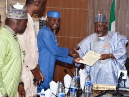 Minister of Defence, Muhammad Badaru Abubakar, CON (R) receiving report from the Chairman of the Military Veterans Welfare Committee, Air Commodore Olufemi Oguntunyi (Rtd.) in Ship House, Abuja
