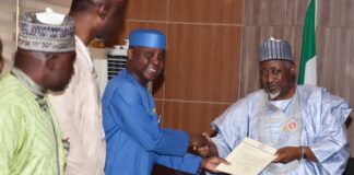Minister of Defence, Muhammad Badaru Abubakar, CON (R) receiving report from the Chairman of the Military Veterans Welfare Committee, Air Commodore Olufemi Oguntunyi (Rtd.) in Ship House, Abuja