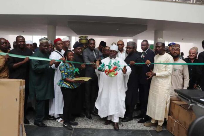 Minister of Special Duties Minister of Special Duties and Inter-governmental Affairs, Zaphaniah Jisalo, (m) commissions the equipment assisted by dignitaries at the event