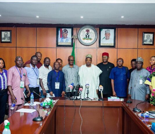 The honourable Minister of Budget and Economic Planning, Sen. Abubakar Atiku Bagudu flanked to the right by the Permanent Secretary of the Ministry, Engr. Nebeolisa Anako and members of the press