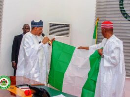 HE Governor Abba Kabir Yusuf's of Kano State presenting the National Flag to the Hon. Minister of Information and National Orientation, Alhaji Mohammed Idris Malagi
