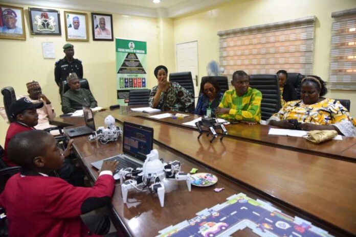 Curriculum Review in Education Sector2 Honorable Minister of State for Education, Hon. Yusuf Tanko Sununu (middle row,3rd right) in a group photograph with STEM Child Care during a courtesy visit to exhibit projects on Artificial intelligence (AI) and Robotics in Abuja on Tuesday.