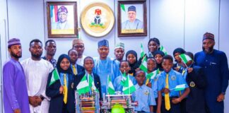 Minister of Information and National Orientation, Mohammed Idris (center), in a group photograph with the students, coaches, and the school's Executive Director, Abba Said (Extreme right)