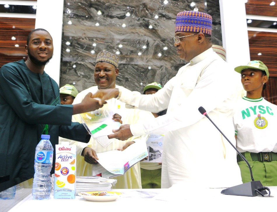 L-R: Corp Member Alfa Lucky Ojochogwu, Permanent Secretary, Dr. Nasir Sani Gwarzo; Minister of Police Affairs, Senator Ibrahim Gaidam; and Corp members during the presentation of a report on the Role of Corpers (NYSC) in improving policing in Nigeria held at the Education conference room, Federal Secretariat, Abuja