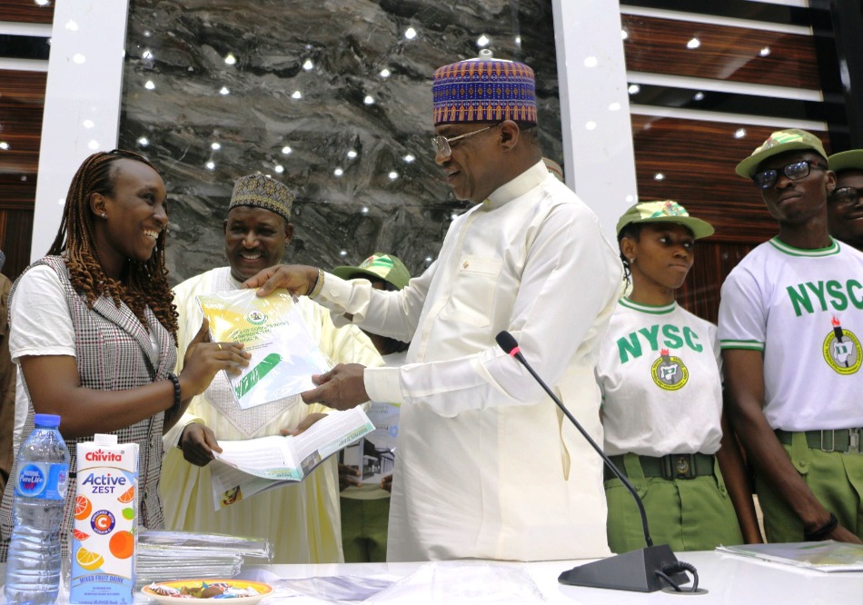 L-R: Corp Member Mene Eyimofe Edith, Permanent Secretary, Dr. Nasir Sani Gwarzo; Minister of Police Affairs, Senator Ibrahim Gaidam; and Corp members during the presentation of a report on the Role of Corpers (NYSC) in improving policing in Nigeria held at the Education conference room, Federal Secretariat, Abuja