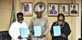 Permanent Secretary, Ministry of Petroleum Resources, Amb. Nicholas Agbo Ella, flanked to the right by the Ministry's Head, Legal Services, Mrs Kate O. Olusuyi and left by Chairman, FOSSREA, Mr. Aliyu Hydar Mijinyawa, displaying the signed documents during the signing of the agreement ceremony in Abuja.