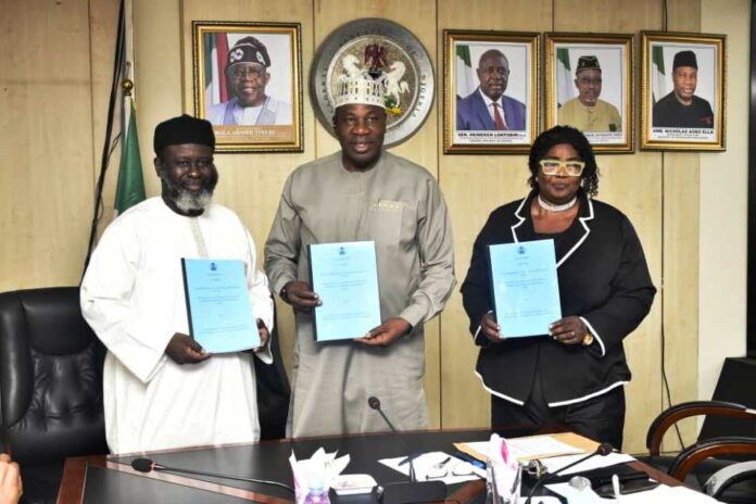 Permanent Secretary, Ministry of Petroleum Resources, Amb. Nicholas Agbo Ella, flanked to the right by the Ministry's Head, Legal Services, Mrs Kate O. Olusuyi and left by Chairman, FOSSREA, Mr. Aliyu Hydar Mijinyawa, displaying the signed documents during the signing of the agreement ceremony in Abuja.