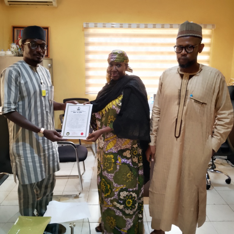 Executive Director, NIWRMC, Hajiya Sakinatu Abbo Jimeta(M) making presentation of the Water Use Licence to Rabiu Maska, the Social Performance Specialist, BUA Cement (L), flanked by the Director, Allocation and Authorization, Engr. Shazali Uba Ajingi (R) in NIWRMC, Abuja